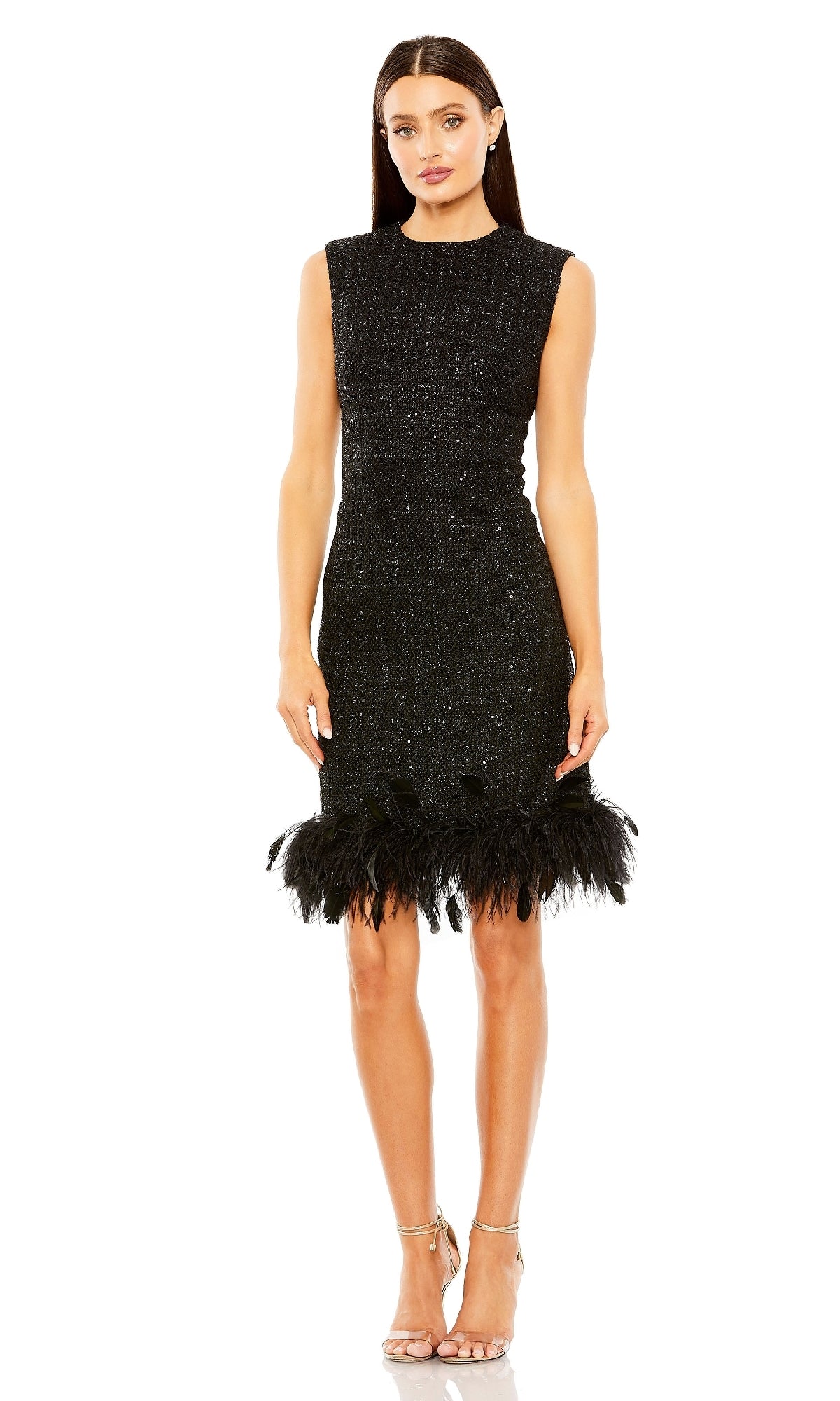 A woman wears the Mac Duggal 20784 short black shimmer party dress with a feather-trimmed hem, styled with strappy high-heeled sandals.